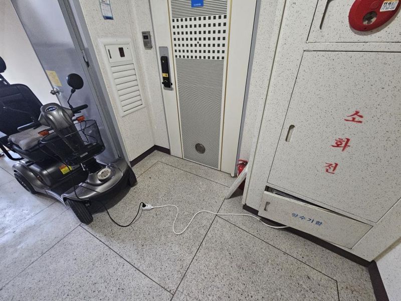 아파트 공용 전기로 '전동 휠체어' 충전하는 노인