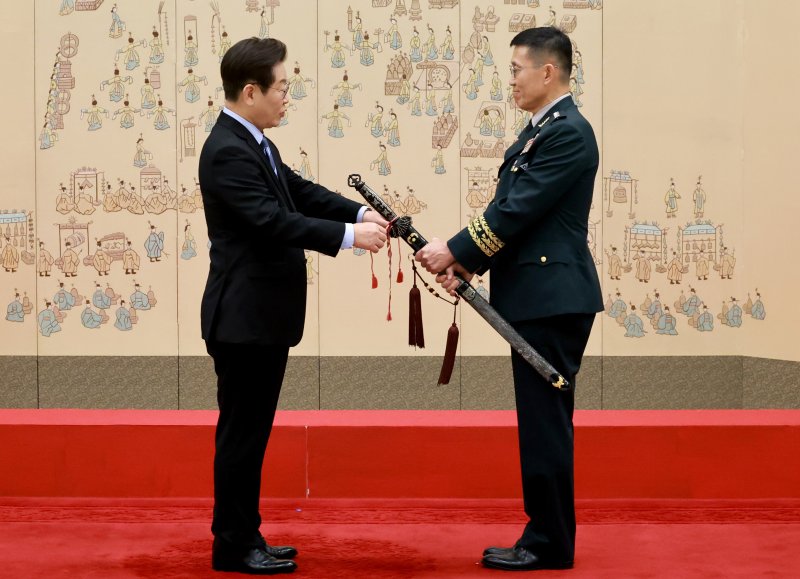 [서울=뉴시스] 최동준 기자 = 이재명 대통령이 2일 서울 용산 대통령실 청사에서 열린 대장 진급·보직 신고 및 삼정검 수치 수여식에서 김규하 육군참모총장의 삼정검에 수치를 달아주고 있다. (대통령실통신사진기자단) 2025.09.02. photocdj@newsis.com