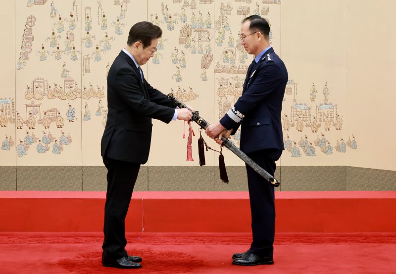 [서울=뉴시스] 최동준 기자 = 이재명 대통령이 2일 서울 용산 대통령실 청사에서 열린 대장 진급·보직 신고 및 삼정검 수치 수여식에서 손석락 공군참모총장의 삼정검에 수치를 달아주고 있다. (대통령실통신사진기자단) 2025.09.02. photocdj@newsis.com