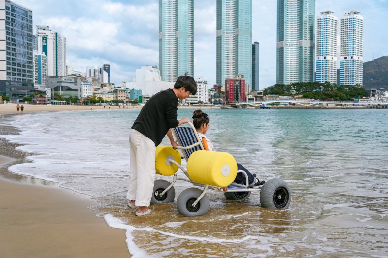 [부산=뉴시스] 복지플랜 주식회사가 자체 개발한 '수상 휠체어'를 활용해 이동에 어려움이 있는 이들도 안전하고 편리하게 여행할 수 있도록 무장애 해양 관광 프로그램을 운영하고 있는 모습. (사진=부산관광공사 제공) 2025.07.10. photo@newsis.com *재판매 및 DB 금지