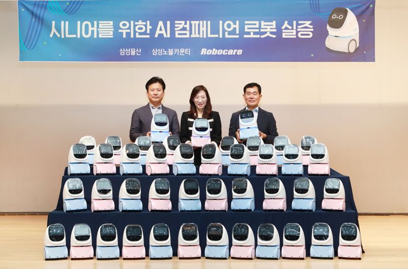 삼성노블카운티 박성현 대표(왼쪽부터), 삼성물산 조혜정 DxP본부장, 로보케어 문전일 대표이사가 홈 AI 컴패니언 로봇 3사 실증 시작 기념행사에서 사진을 촬영하고 있다. 삼성물산 건설부문 제공