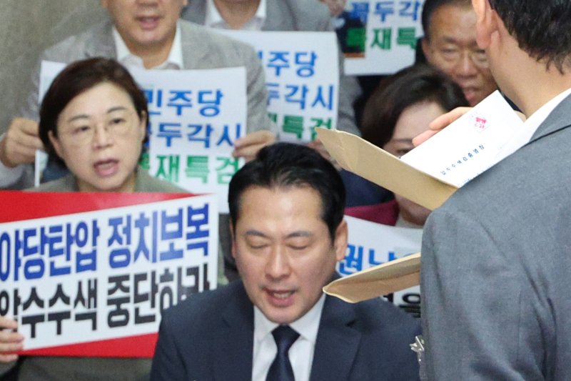 국민의힘 의원들이 3일 오후 서울 여의도 국회 국민의힘 원내대표실 앞에서 긴급 의원총회를 가진 가운데 내란특검 수사관들이 원내대표실 압수수색에 나서며 영장을 꺼내고 있다. 2025.9.3/뉴스1 ⓒ News1 신웅수 기자