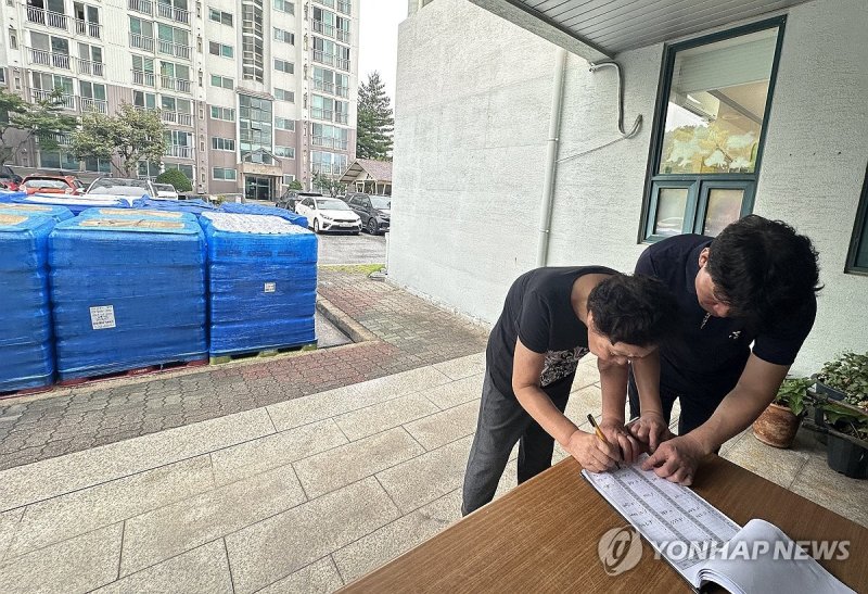 생수 지원 명부 작성하는 주민 (출처=연합뉴스)