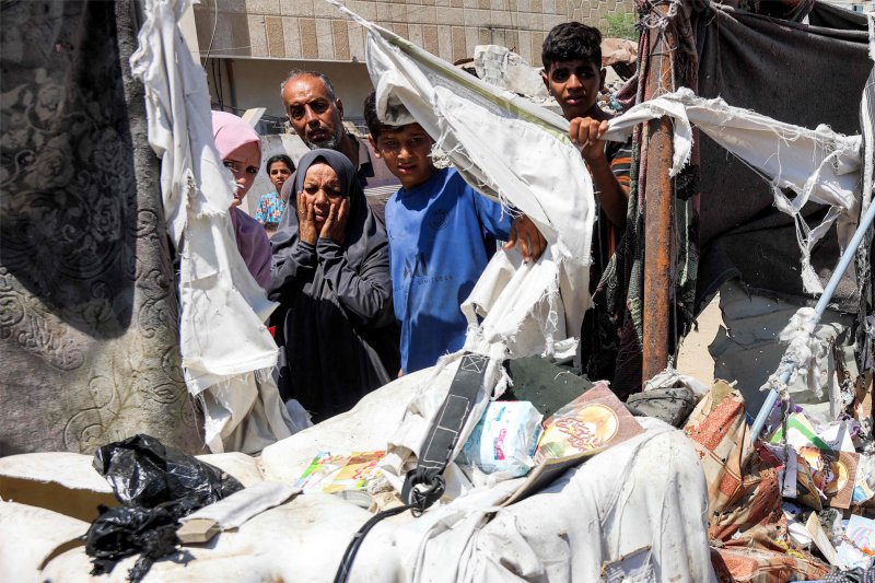 4일(현지시간) 팔레스타인 가자지구 가자시티의 알 시파 병원 인근 난민촌에서 현지 주민들이 이스라엘 공습에 따른 피해를 확인하고 있다.AFP연합뉴스