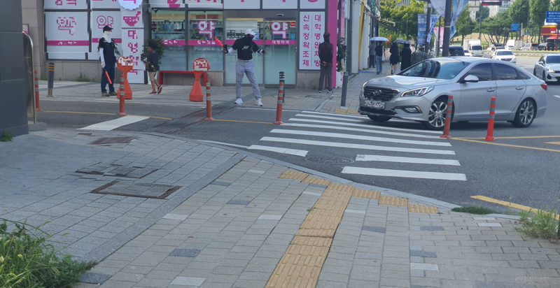 지난 3일 경광봉을 든 약국 직원들이 아산병원 인근에 위치한 잠실올림픽공원 아이파크 단지 주차장으로 차량 진입을 유도하고 있다. 아파트 입주민 노모씨(50대)은 "약국 셔틀 차량이 수시로 제집 드나 들듯이 주차장을 드나든다"며 "입주민은 강제로 다른 출입구로 다녀야한다"고 불만을 토로했다. 사진=최승한 기자