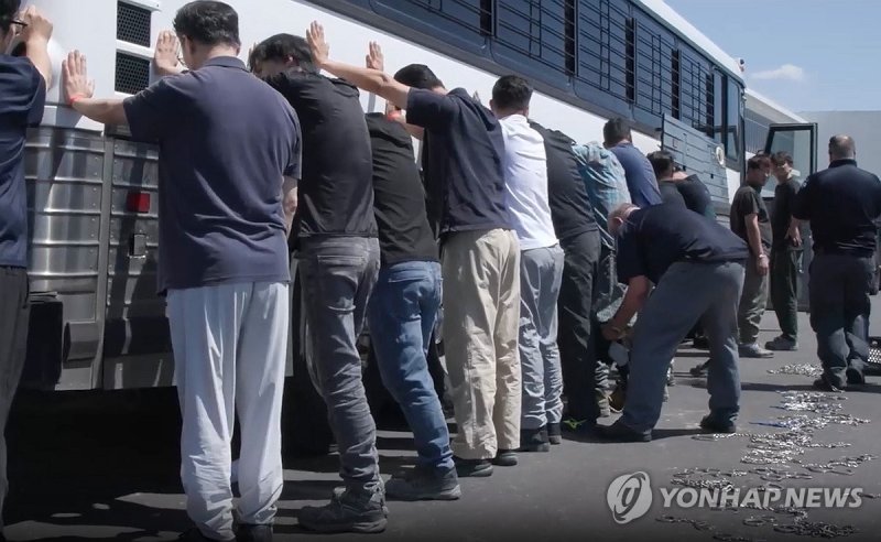 양손과 다리에 체인 묶는 단속요원들 (출처=연합뉴스)