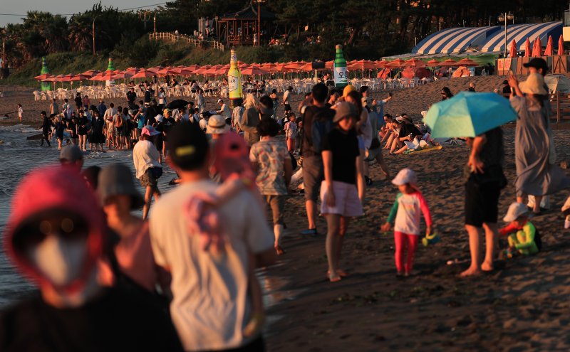 [제주=뉴시스] 우장호 기자 = 폭염이 기승을 부린 6일 오후 해가 저문 제주시 이호테우해수욕장에 피서객들이 해변에 남아 바닷바람을 맞으며 더위를 식히고 있다. 2025.07.06. woo1223@newsis.com