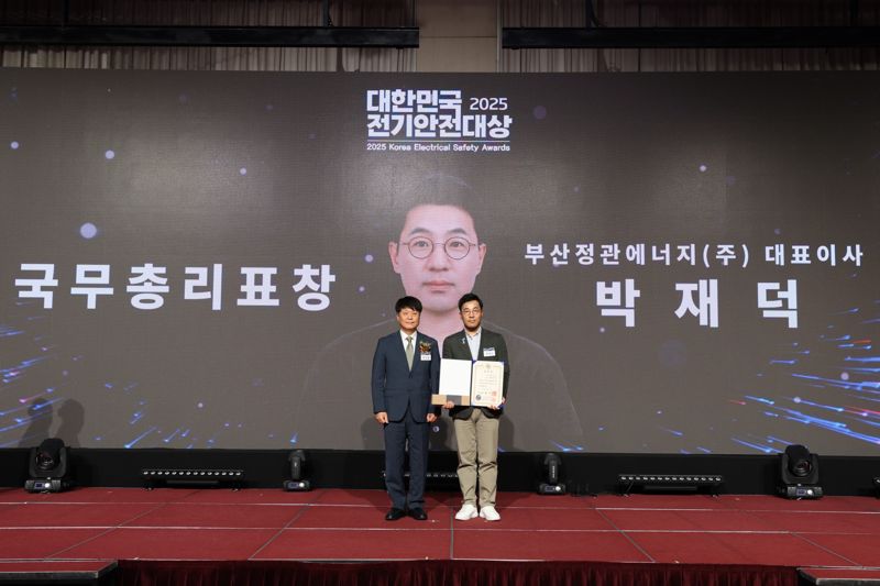 박재덕 부산정관에너지 대표(오른쪽)가 지난 8일 서울 세종대학교 컨벤션센터에서 열린 '제28회 대한민국 전기안전대상' 시상식에서 국무총리 표창을 수상한 뒤 기념촬영을 하고 있다. SK이노베이션 E&S 제공