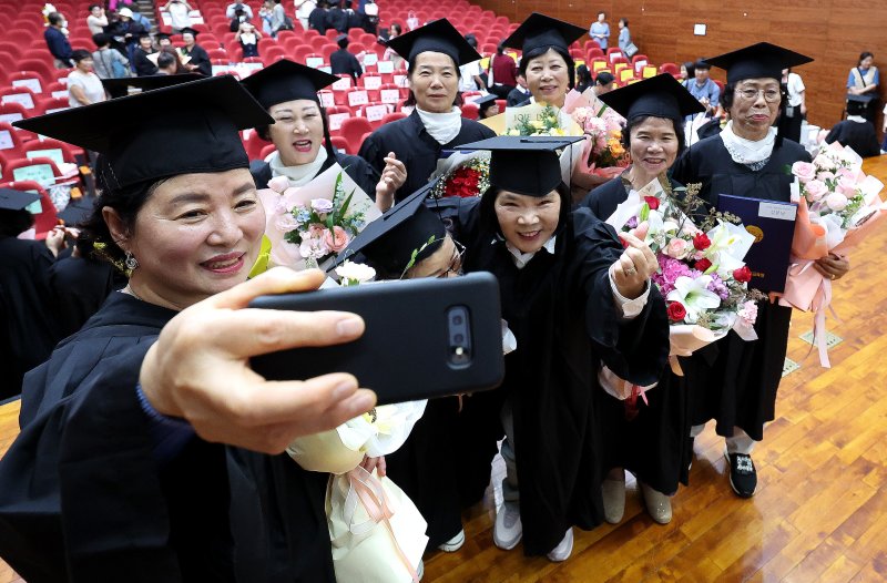 [대구=뉴시스] 이무열 기자 = 9일 대구 수성구 대구시교육청 행복관에서 열린 ‘대구내일학교 초등 제13회·중학 제10회 졸업식’에서 졸업생들이 졸업 가운과 학사모를 쓰고 기념사진을 찍고 있다.내일학교는 배움의 시기를 놓친 성인을 위해 대구시교육청이 초·중등 학력 인정 프로그램을 운영하는 교육기관이다. 2025.09.09. lmy@newsis.com