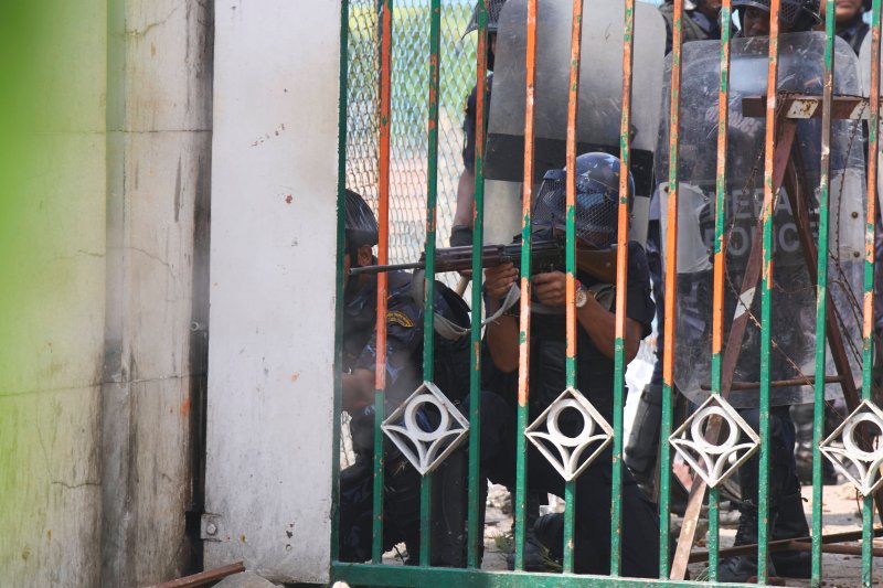 [카트만두=AP/뉴시스] 8일(현지 시간) 네팔 카트만두 의사당 건물에서 한 시위 진압 경찰관이 시위대를 향해 총기를 겨누고 있다. 시위대는 정부의 소셜미디어 금지에 항의하며 의회 진입을 시도했으며 이 과정에서 경찰의 총격을 받아 최소 10명이 숨지고 수십 명이 부상했다. 2025.09.09.