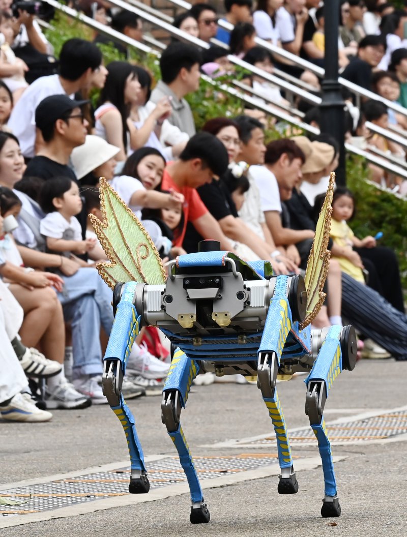[용인=뉴시스] 김종택 기자 = 9일 경기 용인시 에버랜드에서 열린 '스마일리 펌킨 퍼레이드'에서 국내 최초로 인공지능(AI) 보행 기능을 탑재한 4족보행 로봇이 음악에 맞춰 퍼포먼스를 선보이고 있다. 4족보행 로봇은 레인보우로보틱스의 'RBQ 시리즈'로, 시각정보 없이도 AI 보행만으로 계단, 경사로 등을 안정적으로 걸을 수 있고 물구나무서기, 옆발 서기 같은 고난도 동작을 구현할 수 있다. 2025.09.09. jtk@newsis.com