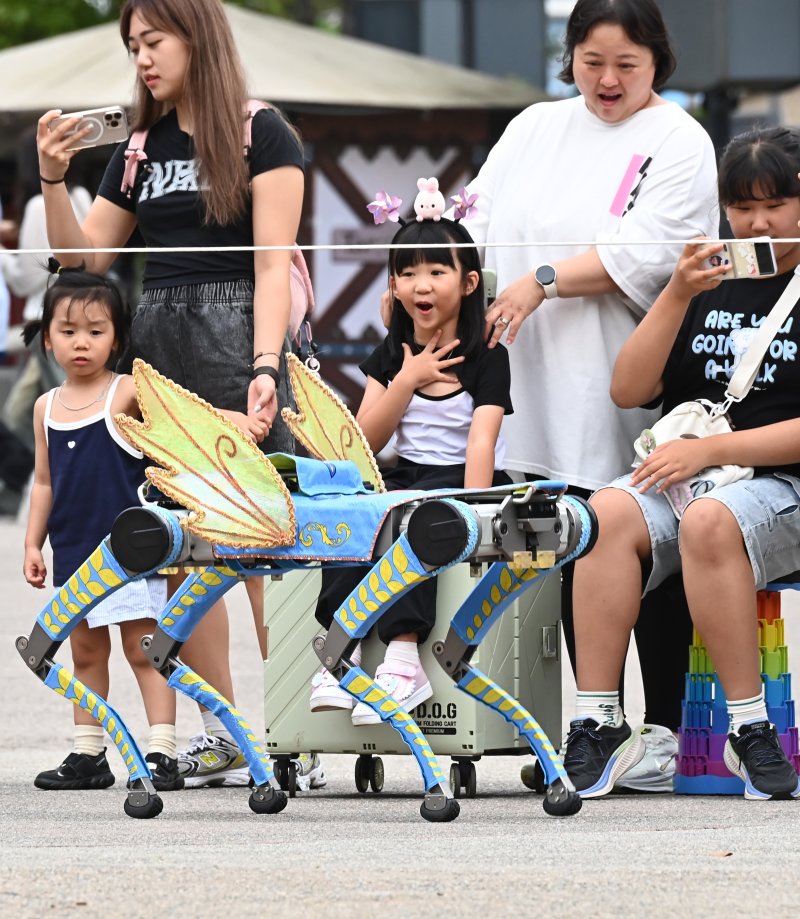 [용인=뉴시스] 김종택 기자 = 9일 경기 용인시 에버랜드에서 열린 '스마일리 펌킨 퍼레이드'에서 국내 최초로 인공지능(AI) 보행 기능을 탑재한 4족보행 로봇이 음악에 맞춰 퍼포먼스를 선보이고 있다. 4족보행 로봇은 레인보우로보틱스의 'RBQ 시리즈'로, 시각정보 없이도 AI 보행만으로 계단, 경사로 등을 안정적으로 걸을 수 있고 물구나무서기, 옆발 서기 같은 고난도 동작을 구현할 수 있다. 2025.09.09. jtk@newsis.com