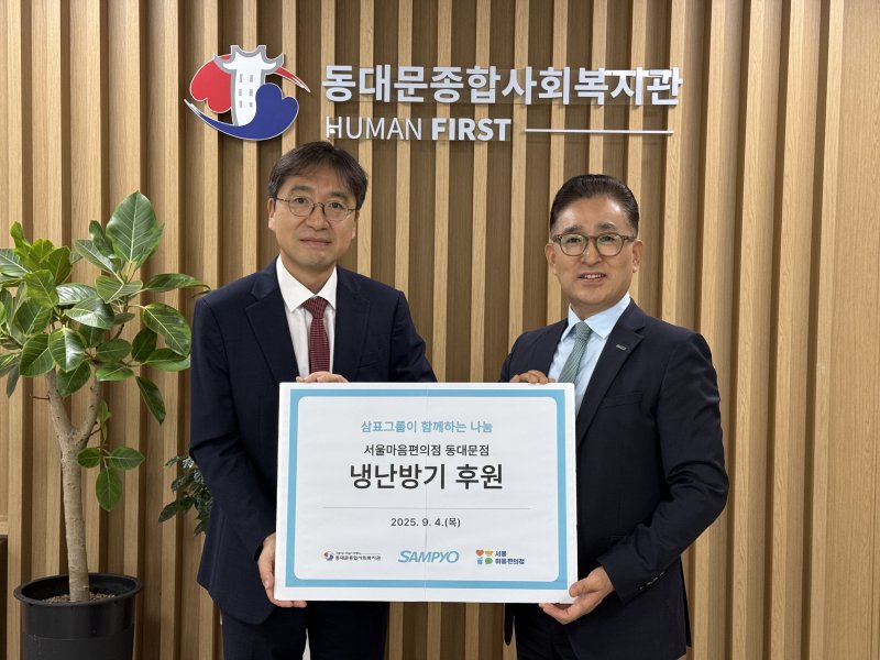 유용재 삼표그룹 상무(왼쪽)가 지난 4일 동대문종합사회복지관에서 정만복 동대문종합사회복지관장과 기념 촬영을 하고 있다. 삼표그룹 제공