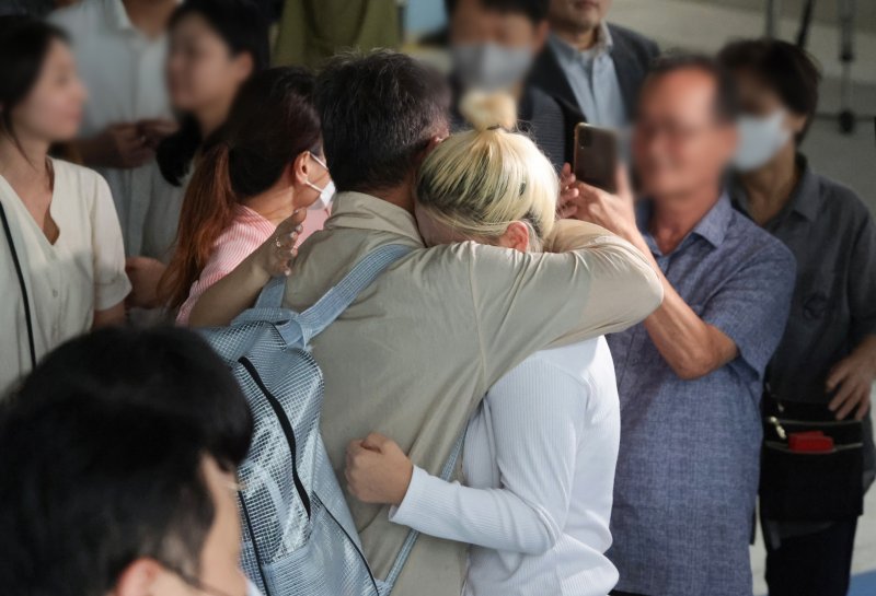 미국의 이민 단속으로 체포됐던 미국 현대차·LG엔솔 배터리공장 건설 현장 직원이 12일 인천국제공항 제2터미널로 귀국한 뒤 장기주차장에서 대기 중이던 가족과 만나 포옹하고 있다. 뉴시스