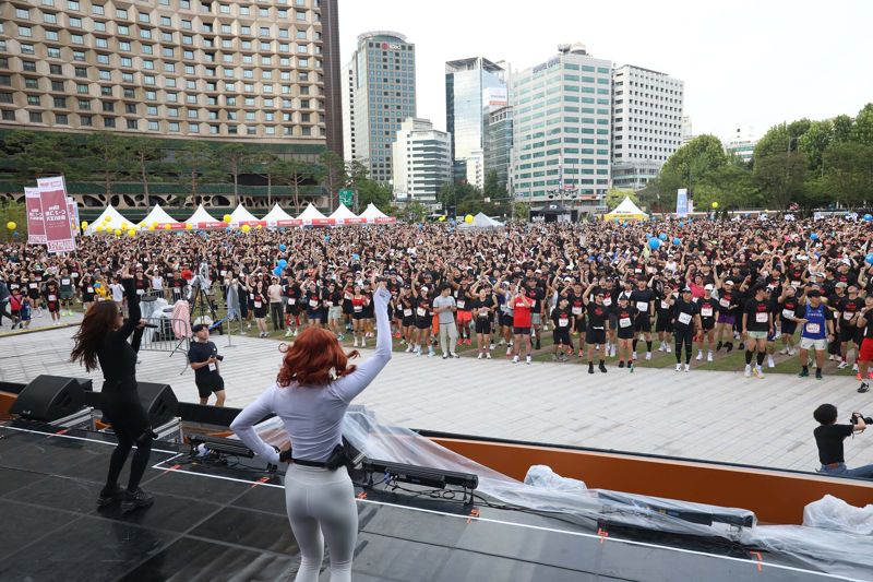 14일 서울광장에서 열린 ‘마블런 서울 2025’ 행사에서 행사 참가자들이 함께 어울려 준비 운동을 하며 도심 축제를 즐기고 있다. /디즈니코리아 제공