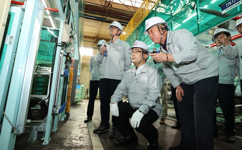 이호성 하나은행장이 지난 15일 경기 시흥시 서진산업을 방문해 최재홍 서진산업 대표이사로부터 생산시설에 대한 설명을 듣고 있다. 하나은행 제공