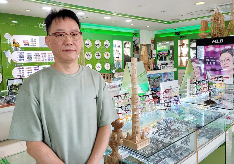수눌음안경원 사장 여호근 씨. 뒤로 그가 이쑤시개로 제작한 작품들이 보인다.
