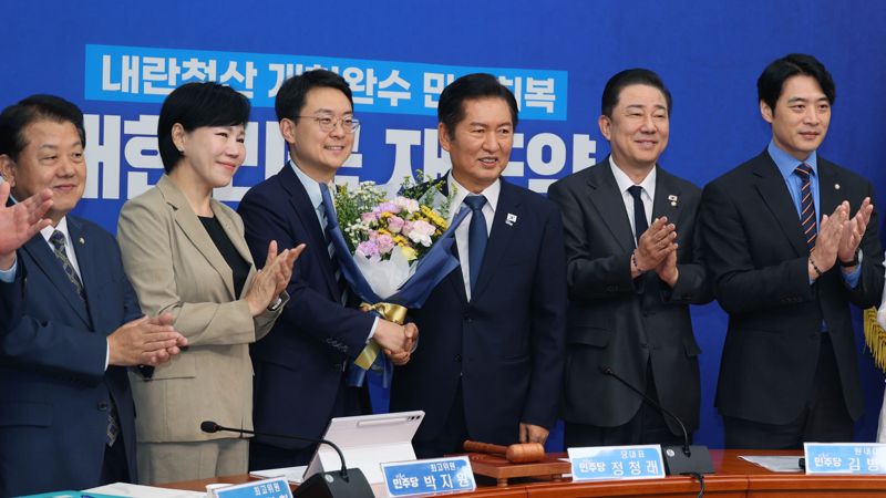 더불어민주당 정청래 대표가 19일 서울 여의도 국회에서 열린 최고위원회의에서 박지원 신임 평당원 최고위원에게 꽃다발을 전달한 후 기념촬영을 하고 있다. 사진=서동일 기자