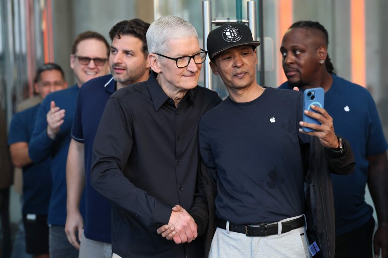 팀 쿡(앞줄 왼쪽) 애플 최고경영자(CEO)가 아이폰17 출시 첫 날인 지난달 19일(현지시간) 미국 뉴욕 5번가 애플 매장에서 고객과 함께 기념사진을 찍고 있다. AFP 연합