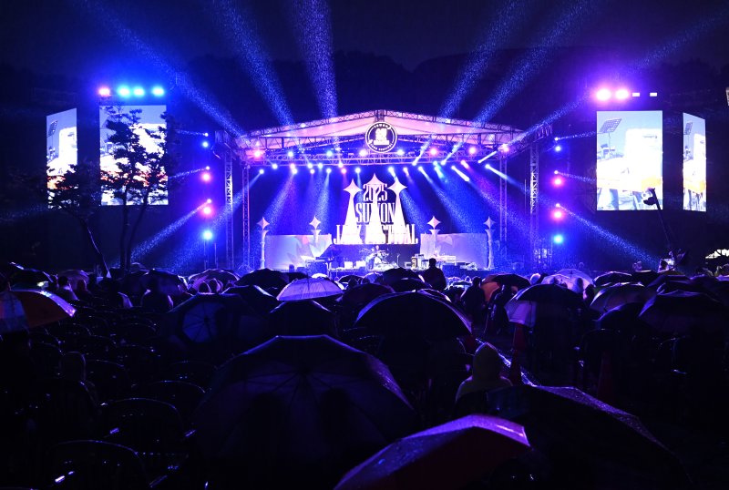 [수원=뉴시스] 김종택 기자 = '2025 수원재즈페스티벌'이 열린 19일 오후 경기 수원시 광교호수공원 재미난 밭에서 잔디광장을 가득 메운 시민들이 흥겨운 재즈 선율을 즐기고 있다. 2025.09.19. jtk@newsis.com