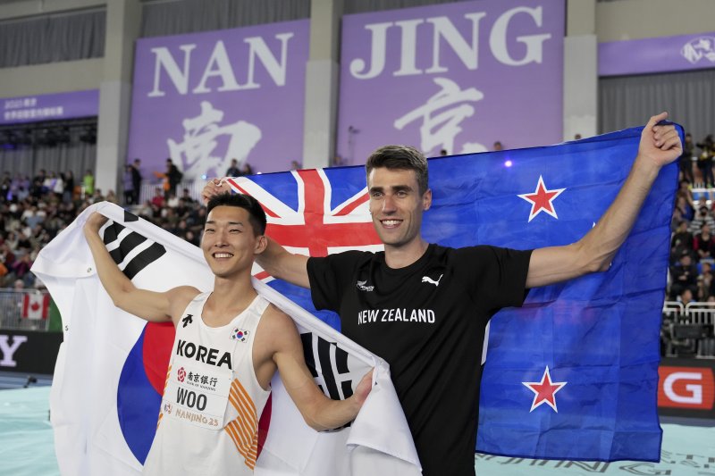 [난징=AP/뉴시스] 우상혁이 지난 21일 중국 난징에서 열린 세계 육상 실내 선수권 대회 남자 높이뛰기 결승전에서 금메달을 획득한 후 은메달을 획득한 뉴질랜드 해미시 커와 기념촬영을 하고 있다. 2025.03.21.