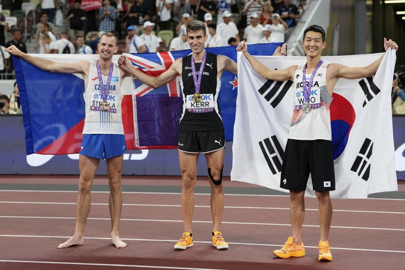 [도쿄=AP/뉴시스] 우상혁(오른쪽)이 지난 16일 일본 도쿄 국립경기장에서 열린 2025 도쿄 세계육상선수권대회 남자 높이뛰기 결선에서 2ｍ34로 은메달을 획득한 뒤 금메달의 해미시 커(뉴질랜드, 가운데), 동메달의 얀 스테펠라(체코)와 포즈를 취하고 있다. 2025.09.16.