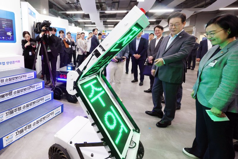 [성남=뉴시스] 고범준 기자 = 이재명 대통령이 17일 경기도 성남시 스타트업 스퀘어에서 스타트업 전시 부스를 방문해 자율주행 순찰 로봇 시연을 관람하고 있다. 2025.09.17. bjko@newsis.com