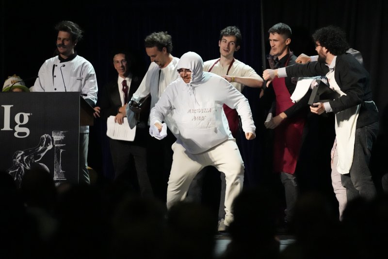 [보스턴=AP/뉴시스] 한 연구팀이 18일(현지 시간) 미 매사추세츠주 보스턴에서 열린 이그노벨상 시상식에서 영양학 부문 이그노벨상을 받고 있다. 이들은 특정 도마뱀이 특정 종류의 피자를 얼마나 더 좋아하는지를 연구해 이 상을 받았다. 노벨상을 패러디한 이그노벨상(Ig Nobel Prize)은 '바보 같지만, 의미 있는 연구' 또는 '기발하고 엉뚱하지만, 생각할 거리를 주는 연구'를 한 사람이나 단체에 주어진다. 2025.09.19.