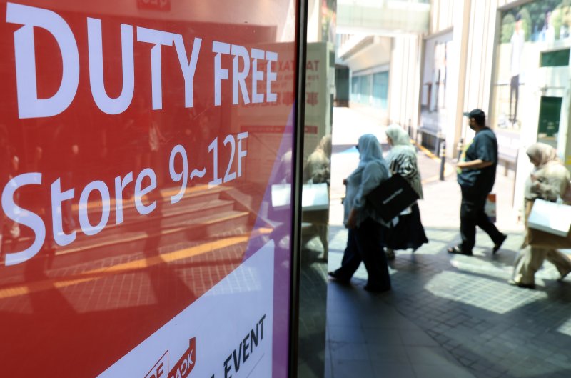 서울 시내 한 면세점 광고판 앞으로 외국인 관광객들이 지나고 있다. 2025.8.7/뉴스1 ⓒ News1 박정호 기자