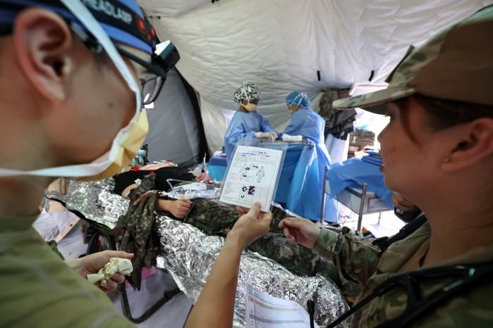 한미연합군사령부는 지난 18일 ‘연합·합동 의무지원훈련’을 주관하고 최전방 대규모 전상자 의무지원 전 과정을 검증했다. 한미 의료진이 연합 야전병원시설 수술실에서 다리 절단환자의 응급수술 전 논의를 하고 있다. 국방일보 제공