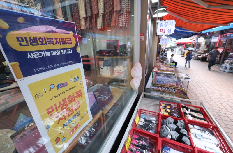 소득 상위 10%를 제외한 국민 90%에게 1인당 10만원을 추가 지급하는 2차 '민생회복 소비쿠폰' 신청과 지급이 시작된 22일 서울의 한 전통시장에 민생 회복 지원금 사용가능 안내문이 붙어 있다. 뉴시스 제공