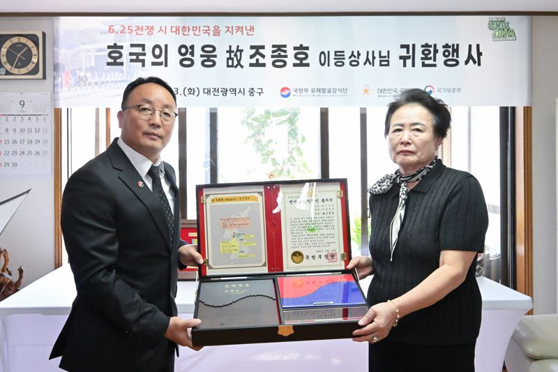 조해학 국유단장 직무대리(사진 왼쪽)가 유가족인 아들 조정원 씨의 배우자 전우혜 씨(74세))에게 호국의 얼 함을 전달하고 있다.jpg