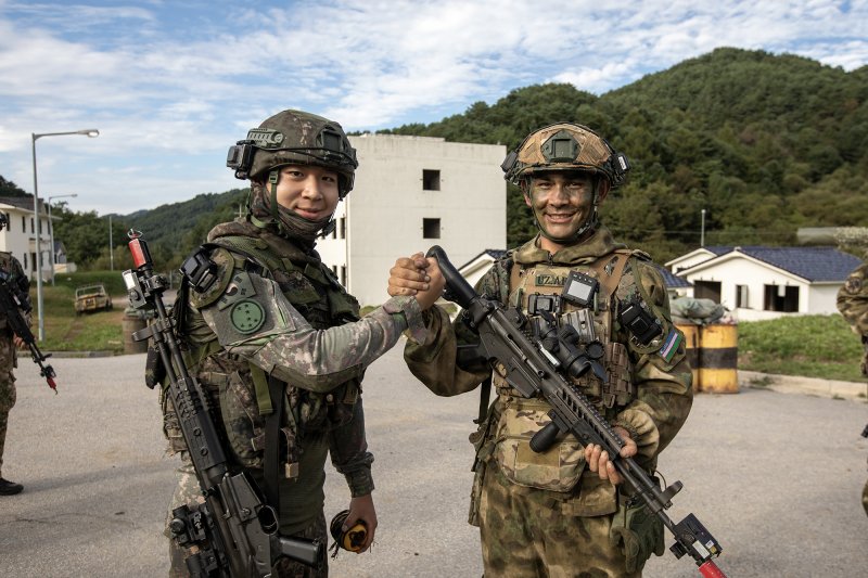 육군이 지난 22일부터 26일까지 강원 인제군 육군 과학화전투훈련단에서 제3회 국제 과학화전투 경연대회를 실시했다고 27일 밝혔다. 사진은 도시지역 교장에서 국가대항전투를 실시한 후 기념사진을 촬영하고 있는 한국군 및 우즈베키스탄군 장병의 모습. 육군 제공