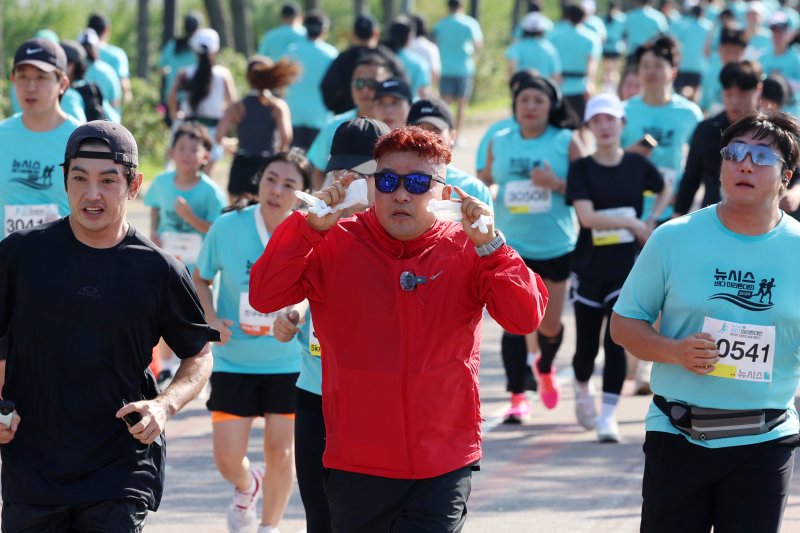 [인천=뉴시스] 조성우 기자 = 1992 바르셀로나 올림픽 금메달리스트인 '몬주익 영웅' 황영조 국민체육진흥공단 감독이 27일 인천 중구 씨사이드파크 하늘구름광장에서 열린 제1회 뉴시스 바다마라톤 대회에서 참가자들과 함께 달리고 있다. 2025.09.27. xconfind@newsis.com