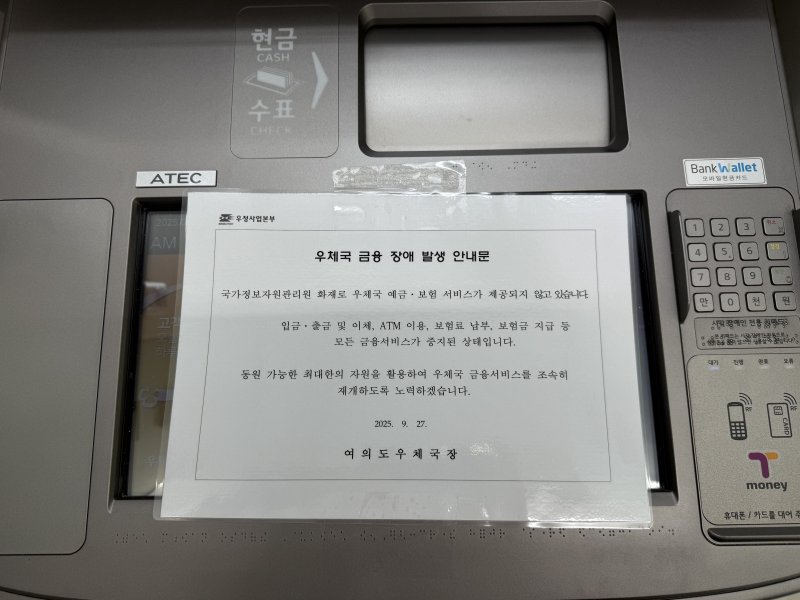 [서울=뉴시스]박나리 수습기자=26일 오후 발생한 대전 국가정보자원관리원 화재로 27일 오전 서울 영등포구 여의도우체국 ATM에 '우체국 예금·보험 등 모든 금융 서비스가 중지'를 알리는 안내문이 붙어 있다.2025.09.27