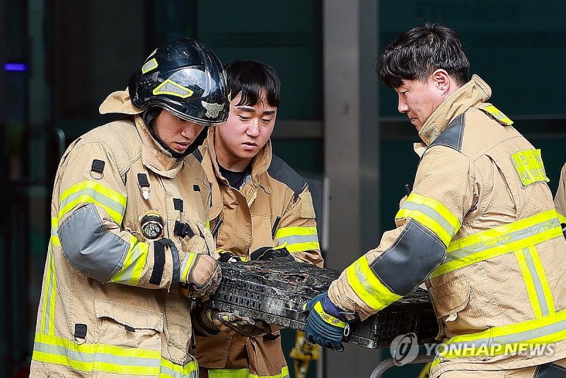 불에 탄 배터리 옮기는 소방대원 (출처=연합뉴스)