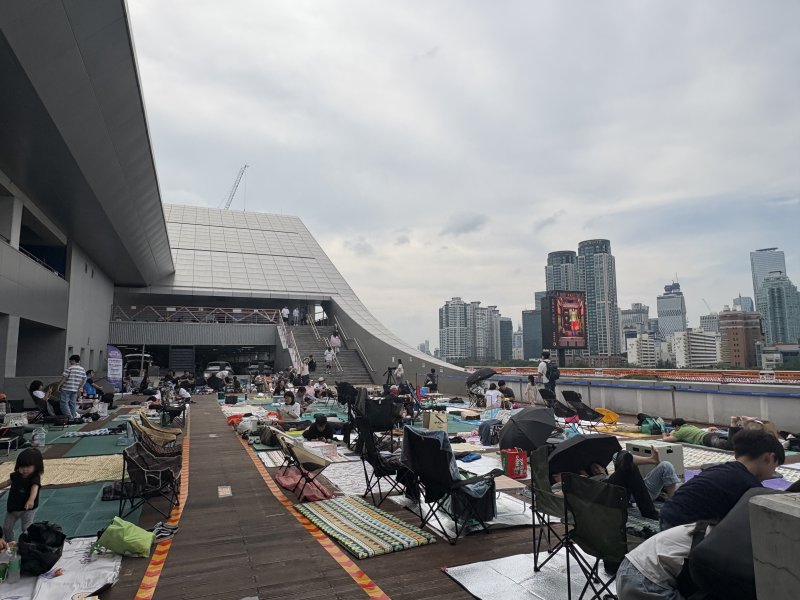 [서울=뉴시스]최은수 기자=2025 서울세계불꽃축제가 열린 27일 오후, 서울 동작구 노량진수산시장 3층 옥외 데크. 여의도 63빌딩을 정면으로 조망할 수 있는 이곳에서 시민들이 돗자리를 펴고 불꽃놀이를 기다리고 있다. 2025.09.27