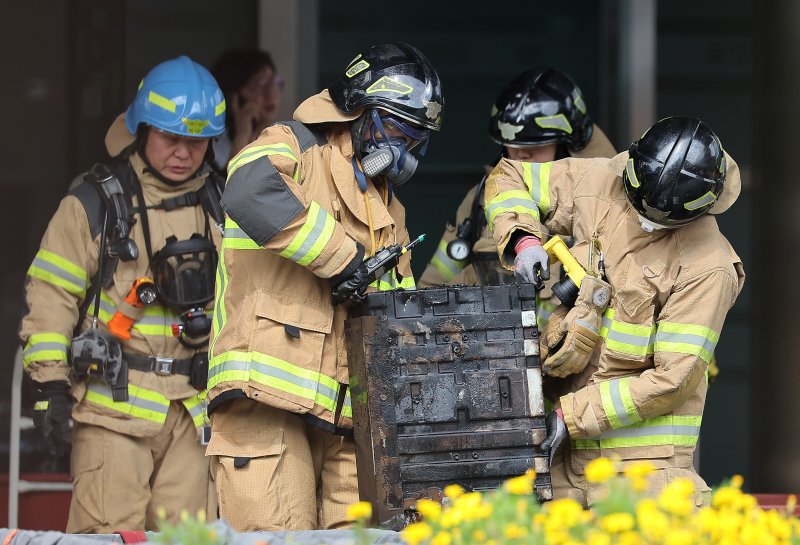 27일 오후 대전 유성구 국가정보자원관리원 화재현장에서 소방당국 관계자들이 소실된 리튬이온배터리에 대한 반출 작업을 하고 있다. 전산 자원을 통합 관리하는 행정안전부 산하 국가정보자원관리원에서 지난 26일 오후 배터리 교체 작업 중 화재가 발생, 정부 온라인 서비스 70개가 마비됐다. 2025.9.27/뉴스1 ⓒ News1 김진환 기자