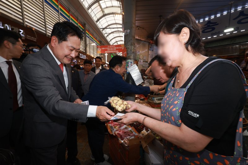 장동혁 국민의힘 대표(왼쪽)가 지난 2일 서울 경동시장을 찾아 추석 음식을 구매하고 있다. 뉴시스