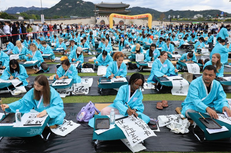 제579돌 한글날을 맞이한 9일 서울 종로구 광화문광장에서 열린 ‘2025 제 16회 광화문광장 휘호대회‘에 참가한 외국인들이 한글을 쓰고 있다. 2025.10.9/뉴스1 ⓒ News1 이호윤 기자