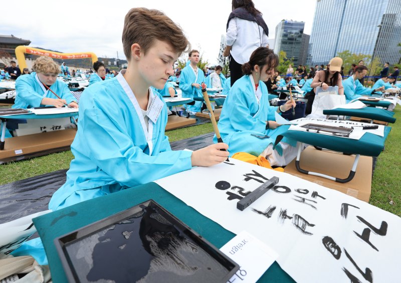 제579돌 한글날을 맞이한 9일 서울 종로구 광화문광장에서 열린 ‘2025 제 16회 광화문광장 휘호대회‘에 참가한 외국인들이 한글을 쓰고 있다. 2025.10.9/뉴스1 ⓒ News1 이호윤 기자