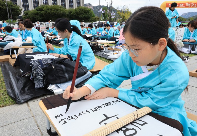 제579돌 한글날을 맞이한 9일 서울 종로구 광화문광장에서 열린 ‘2025 제 16회 휘호대회 휘호대회‘에 참가한 학생이 한글을 쓰고 있다. 이번 대회는 총 35개국 약 400여명이 참가했다. 2025.10.9/뉴스1 ⓒ News1 이호윤 기자