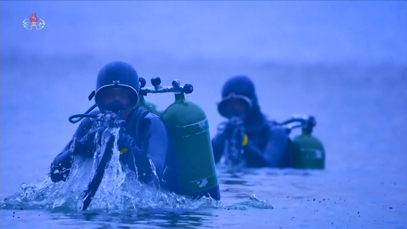 지난 10일 평양 김일성광장에서 열린 북한 조선노동당 창건 80주년 경축 열병식에서 특수부대가 훈련하는 모습을 담은 영상이 상영됐다. 군인들이 잠수함에서 빠져나와 잠수복 차림으로 사격 준비를 하고 있다. 조선중앙TV 캡처