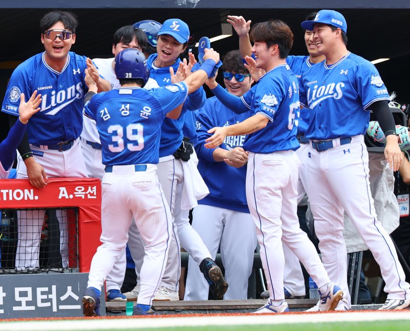 [서울=뉴시스] 박주성 기자 = 11일 인천 미추홀구 SSG랜더스필드에서 열린 2025 KBO 포스트시즌 준플레이오프 2차전 삼성 라이온즈와 SSG 랜더스의 경기, 4회초 원아웃 주자 2, 3루에서 삼성 디아즈의 2타점 적시타 때 홈을 밟은 김성윤이 팀 동료와 기쁨을 나누고 있다. 2025.10.11. park7691@newsis.com