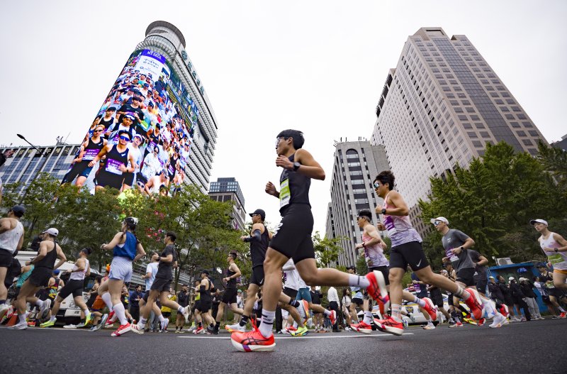 [서울=뉴시스] 김근수 기자 = 12일 오전 서울 종로구 세종대로에서 열린 '2025 서울레이스 마라톤’에서 하프부문 참가자들이 출발선에서 출발하고 있다. 2025.10.12. ks@newsis.com