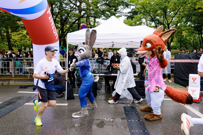 11일 서울 여의도공원에서 디즈니 팬 및 러너들과 함께한 ‘디즈니런 서울 2025’ 행사에서 처음으로 한국을 방문한 주인공 캐릭터 ‘닉’과 ‘주디’가 피니시 라인에서 완주자들을 맞이하고 있다. /디즈니코리아 제공