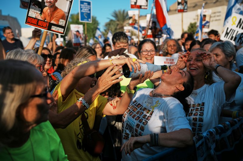 [텔아비브=AP/뉴시스] 13일(현지 시간) 이스라엘 텔아비브의 ‘인질 광장'에서 시민들이 가자지구에서 석방된 이스라엘 인질들의 모습을 생중계로 지켜보며 기뻐하고 있다. 2025.10.13.