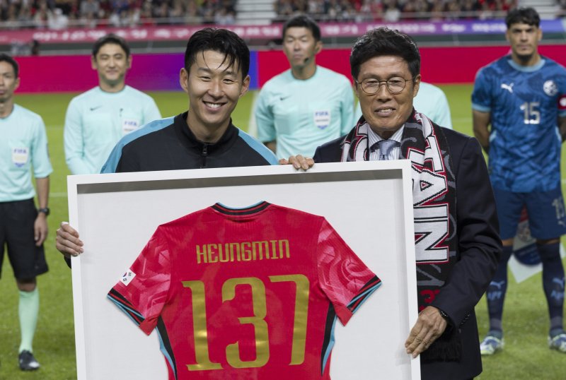 [서울=뉴시스] 김근수 기자 = 한국 남자 선수 A매치 최다 출전한 손흥민이 14일 오후 서울 마포구 서울월드컵경기장에서 열린 하나은행 초청 축구국가대표팀 친선경기 대한민국과 파라과이의 경기 시작 전 차범근 전 감독에게 기념 유니폼을 전달받고 기념촬영을 하고 있다.손흥민은 지난 10일 브라질전에 개인 통산 137번째 A매치에 출전했다. 차범근 전 대표팀 감독, 홍명보 대표팀 감독(이상 136경기)을 제치고 한국 남자 축구 역사상 최다 출전 기록 보유자가 됐다. 2010년 12월 시리아전 데뷔 이후 15년 만이다. 2025.10.14