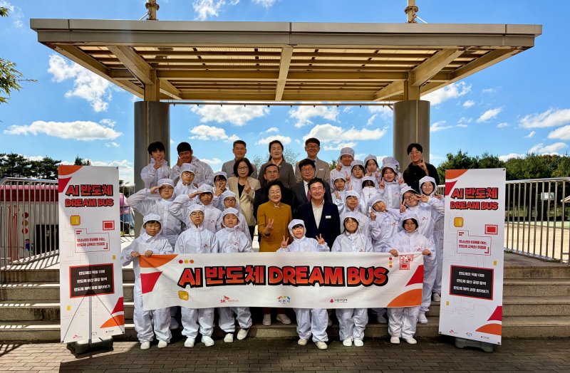 15일 열린 ‘AI 반도체 드림 버스’ 전달식에서 이천사동초 학생들이 방진복을 입고 참석자들과 기념사진을 촬영하고 있다.(SK하이닉스 제공)