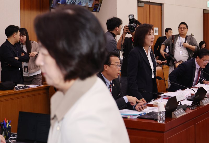 국회 법제사법위원회 감사원 국정감사가 16일 제대로 시작도 못하고 파행됐다. 추미애 법사위원장(왼쪽)이 감사 중지를 선포한 뒤 자리를 떠나고 있는 가운데 나경원 국민의힘 의원(오른쪽)이 일어서서 여당 의원들과 언쟁하고 있다. 연합뉴스